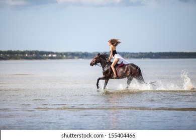 Beautiful young woman riding on a horse