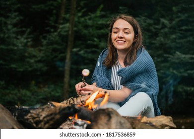 Beautiful Young Woman Roasting Marshmallows Over A Campfire