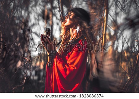 beautiful young woman with shamanic fire outdoors