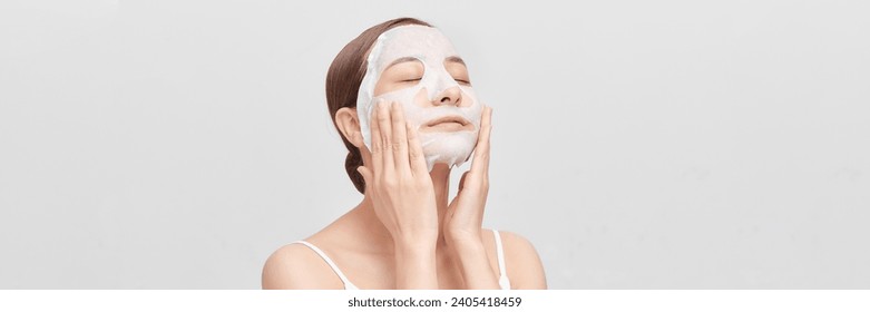 Beautiful young woman with sheet facial mask on color background. panorama - Powered by Shutterstock