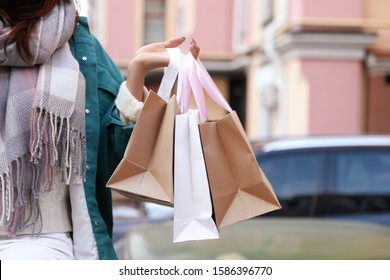 Beautiful young woman with shopping bags outdoors, closeup