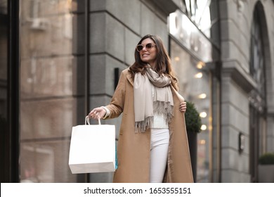 Beautiful Young Woman With Shopping Bags On City Street