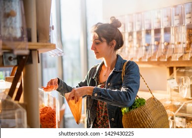 Beautiful Young Woman Shopping In A Bulk Food Store. She Buys Organic Pasta