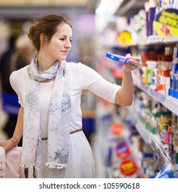 Beautiful Young Woman Shopping For Diary Products At A Grocery Store/supermarket (color Toned Image)