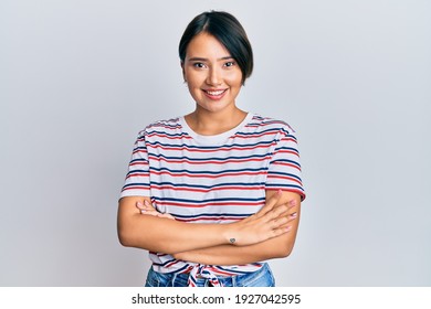 Beautiful young woman with short hair wearing casual clothes happy face smiling with crossed arms looking at the camera. positive person. 