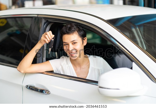 Beautiful young woman showing car key in hand.\
Newbie to drive\
concept.