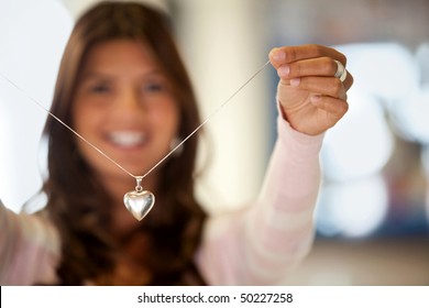 Beautiful Young Woman With Silver Heart Shaped Necklace In Her Hand