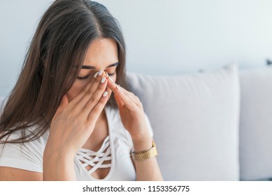 Beautiful young woman with sinus pressure pain. Sinus pain, sinus pressure, sinusitis. Sad woman holding her nose because sinus pain