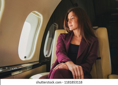 beautiful young woman sits in a plane near the window