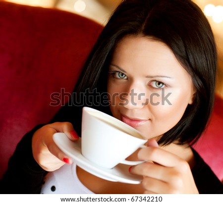 beautiful young woman sitting in a cafe drinking coffee