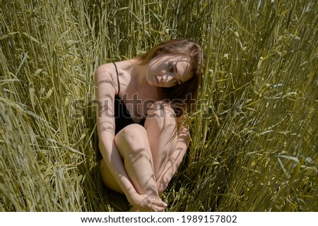 Similar – beautiful young woman siiting outdoors in forest, dreaming with closed eyes in serene pose