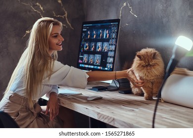 Beautiful young woman is sitting next to the table while her cat is sitting on the table.