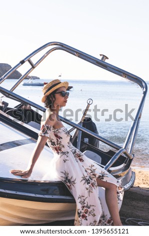 beautiful young woman sitting on yacht and looking forward