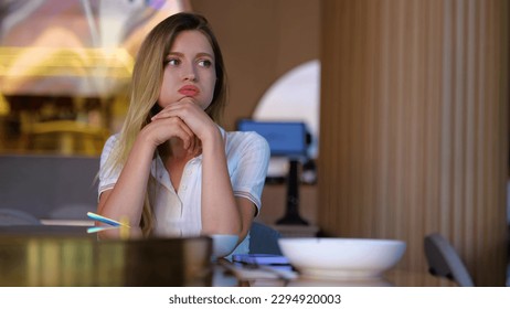 Beautiful young woman sitting in restaurant alone tapping on smartphone waiting for a date. Upset Caucasian blonde pretty female in cafe. Waiting for a meeting. Woman in bar. Close up. Slow motion - Shutterstock ID 2294920003