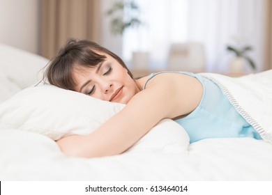 Beautiful Young Woman Sleeping On A Bed In The Bedroom. A Peaceful Sleep Makes You Happy.