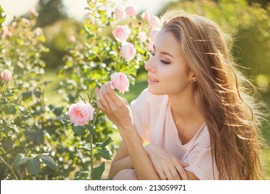 Beautiful Young Woman Smelling A Rose Flower