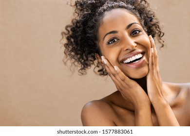Beautiful young woman smiling after fantastic face treatment. Happy beauty african girl excited after spa treatment isolated on background with copy space. Surpise and astonishment beauty concept. - Shutterstock ID 1577883061