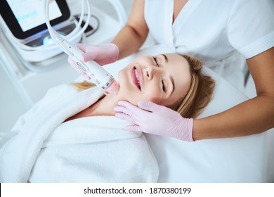 Beautiful Young Woman Smiling During The Skin Treatment With A Fractional Radio Frequency Microneedle Machine