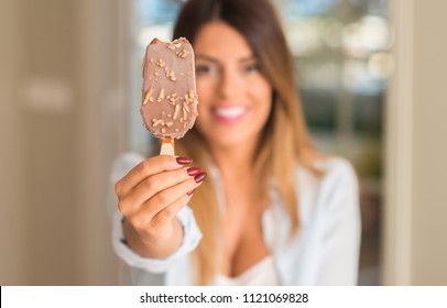 Beautiful Young Woman Smiling Showing Ice Cream At Home. Lifestyle Concept.