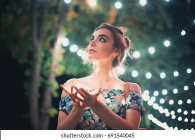 Beautiful Young Woman Smiling And Talking Garlands Of Lights At City