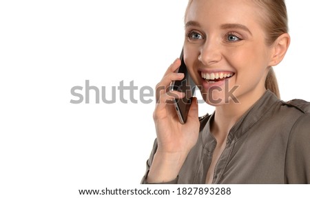 Beautiful young woman smiling and talking on a cell phone. Portrait of a happy girl on a white isolated background. Studio shot. Copy space for your text. 