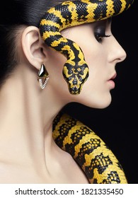 beautiful young woman with Snake. Brunette model girl with fashion make up. Beauty jewelry earrinrs