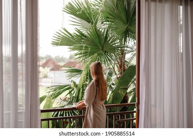 Beautiful Young Woman Stand  On Balcony Terrace Of Jungle Villa With Morning Coffee, Wearing Bathrobe. Vacation On Tropical Island