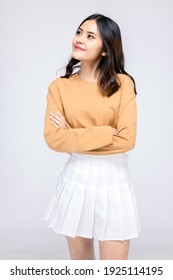 Beautiful Young Woman Standing In Casual Wear , Mixed Race Asian Caucasian Girl. Happy Face, A Confident, Beautiful Woman Isolated On A Gray Background.