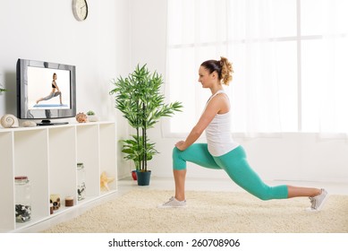 Beautiful Young Woman Stretching Out Her Legs At Home In Front Of The Tv