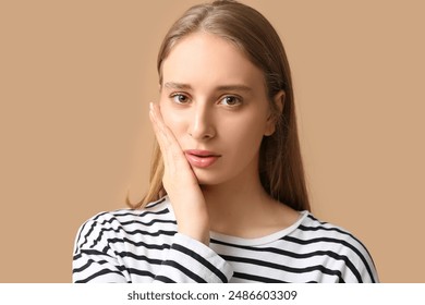 Beautiful young woman suffering from toothache on brown background - Powered by Shutterstock