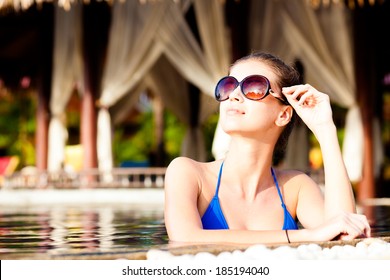 Fashion Model In Swimming Pool Wearing Bikini And Sunglasses Stock