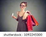 Beautiful young woman in sunglasses with shoppping bags and credit card smiling 