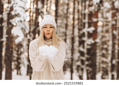 Beautiful young woman in a sweater, knitted hat, mittens blows on snowflakes. Concept of magical winter time, holidays, vacations, gifts, shopping and seasonal sale. - Powered by Shutterstock