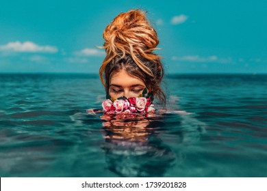 beautiful young woman swimming in sea with wreath conceptual fashion portrait 