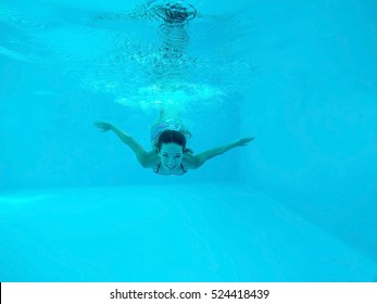 Beautiful Young Woman Swimming Under Water In Pool