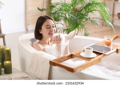 Beautiful young woman taking relaxing bath with foam at home - Shutterstock ID 2101632934
