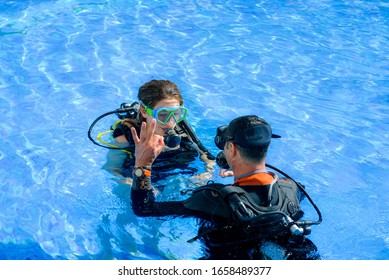 Beautiful Young Woman Taking A Scuba Diving Lesson In Swimming Pool