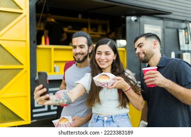 Beautiful young woman taking a selfie with her friends and delicious food truck lunch for social media  - Powered by Shutterstock