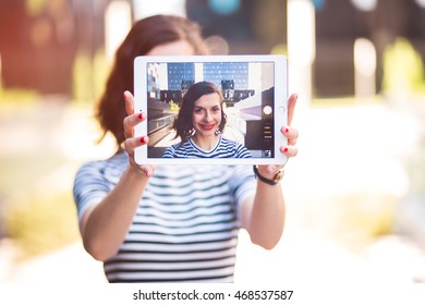 Beautiful Young Woman Taking A Selfie With A Tablet, In The Golden Hour. Focus On The Screen, Graded In An Instagram Style