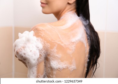 Beautiful young woman taking shower in bathroom