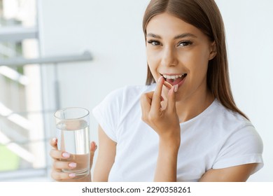 Beautiful Young Woman Taking Yellow Fish Oil Pill - Shutterstock ID 2290358261