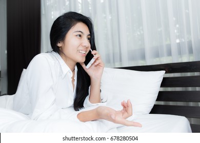 Beautiful Young Woman Talking On The Phone While In Bed