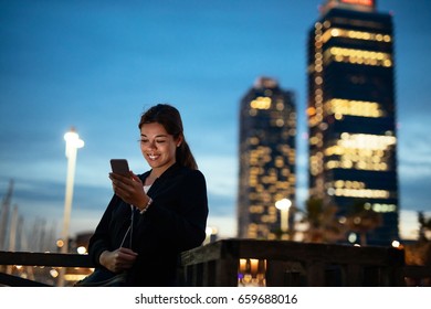 Beautiful Young Woman Texting On The Phone In The City At Night.