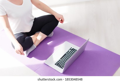 Beautiful young woman training online at home on laptop computer, copy space. Full length portrait. Yoga, pilates, working out exercising - Shutterstock ID 1853048548