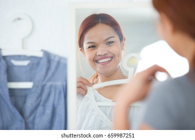 Beautiful Young Woman Trying On Clothes In Front Of Mirror