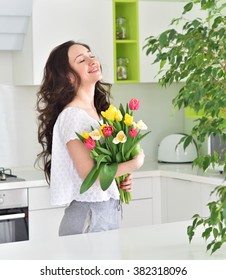 Beautiful Young  Woman With Tulip Bouquet. Spring Portrait. At Home Interior. Mother's Day. Springtime