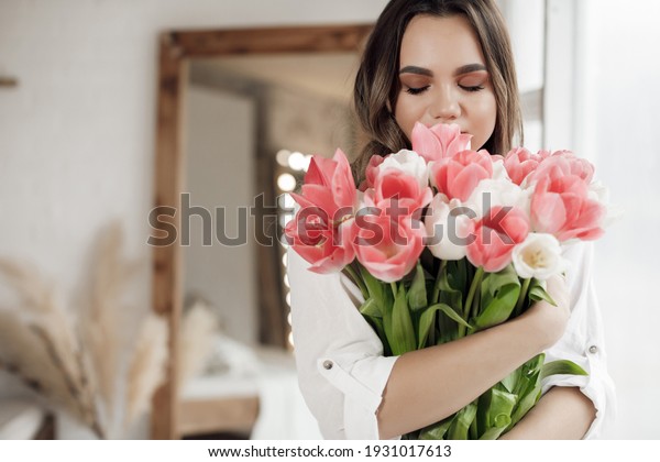 Beautiful young woman
with tulips flowers