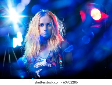Beautiful young woman under the light flashes