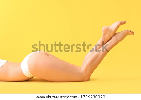 Beautiful young woman in underwear on color background. Concept of cellulite