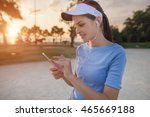 Beautiful young woman is using an app in her smartphone device to play a mobile game in the park